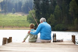 Senior man fishing with grandson